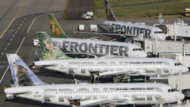 Frontier Airlines planes wait at their gates for the next load of passengers at Denver International Airport.
