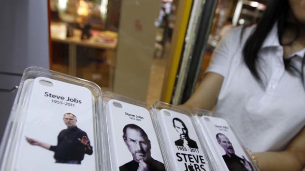 In loving memory ... a shop assistant in Shenzen displays newly released covers for the the iPhone 4.