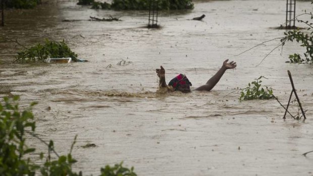Devastation &#8230; a woman struggles in flood waters in Haiti.