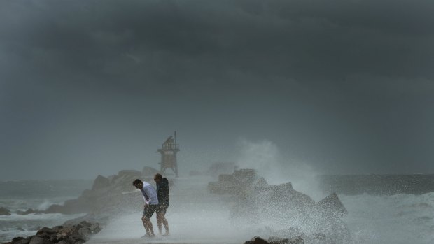 Visitors avoid spray from huge waves at Nobbys Beach, Newcastle.