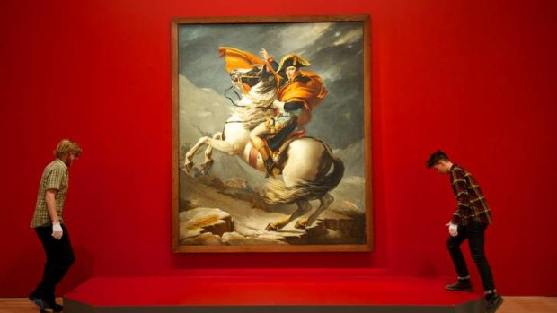 Art handlers Kieran Champion and Somone Tops at the NGV hung the painting <i>Napoleon Bonaparte crossing the Alps</i> (1803) by Jacques-Louis David.