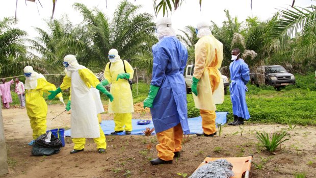 The wrapped remains of a new born child suspected of contracting the Ebola virus, lays on a stretcher as health workers,  move the body for burial in Dubreka, Guinea last week.