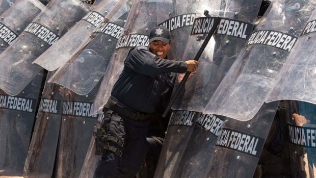 Bringing down barriers &#8230; an instructor pushes on the shields of riot police training to provide security for the G20 leaders' summit in the Mexican resort of Los Cabos.