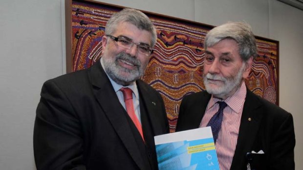 Barry Jones (right), chairman of the Book Industry Strategy Group, presents Industry Minister Senator Kim Carr with his report.