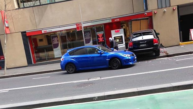 A masked man is seen outside the bank.