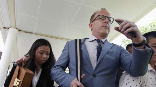 Girlfriend of US researcher Shane Todd, Shirley Sarmiento, leaves with Todd's former neighbour Michael William Goodwin after a coroner's inquiry on the death of Todd.