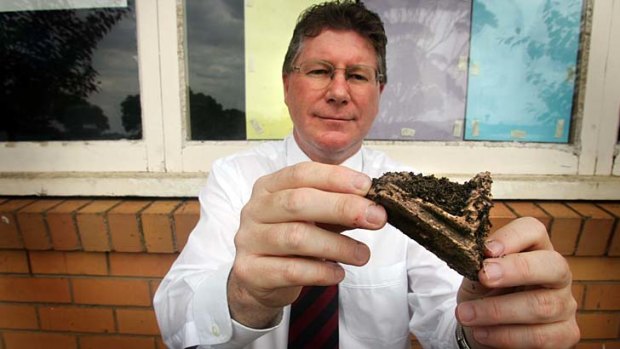 Denis Napthine shows a rotten piece of wood from a school's window pane in 2006.