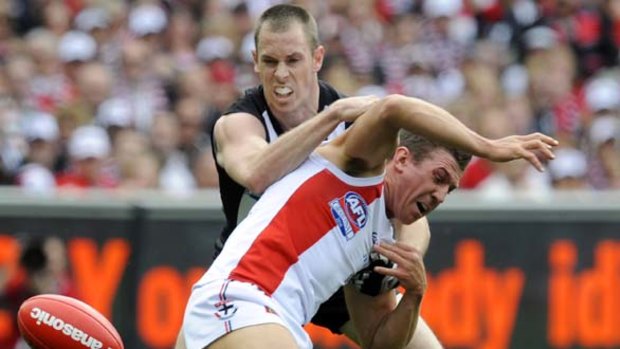 St Kilda's Steve Baker is tackled by Collingwood's Nick Maxwell.