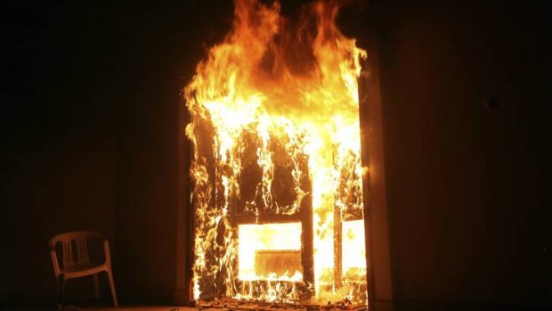 American killed ... the US Consulate in Benghazi in flames during a protest by an armed group.