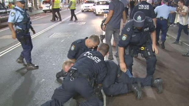 Police detain an alleged brawler on George Street outside the Ivy nightclub.