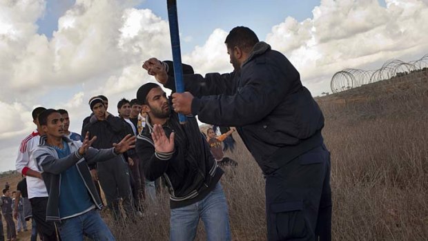 Enforcer &#8230; a Hamas police officer prevents young Palestinians from approaching the Israeli-Gaza border fence in Khan Younis.
