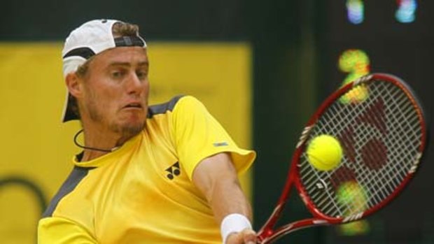 Lleyton Hewitt held on to defeat Roger Federer in Halle, Germany, last night.