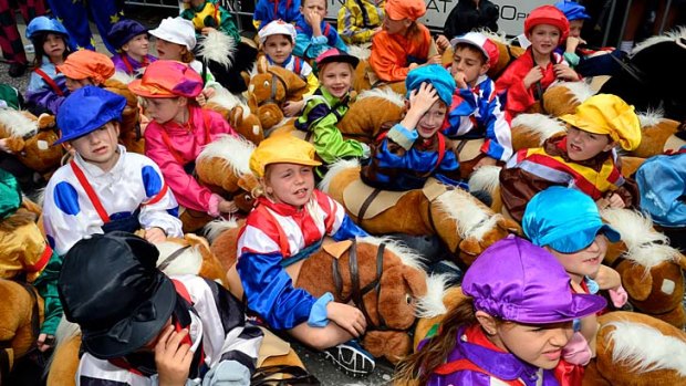 They're off and running: Youngsters get a taste of Melbourne Cup frenzy in the colourful pre-race day parade on Monday.