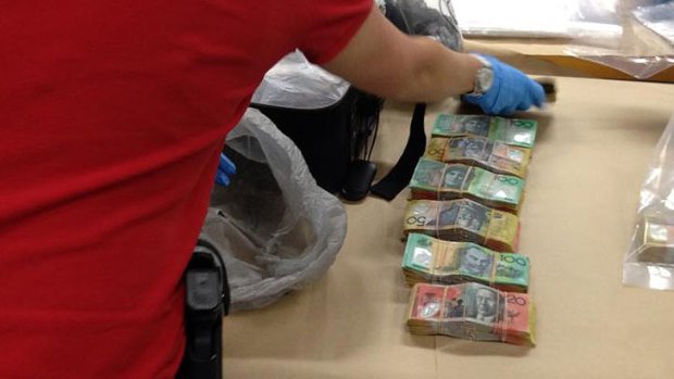 Police with a haul of cash found in an inner-city raid.