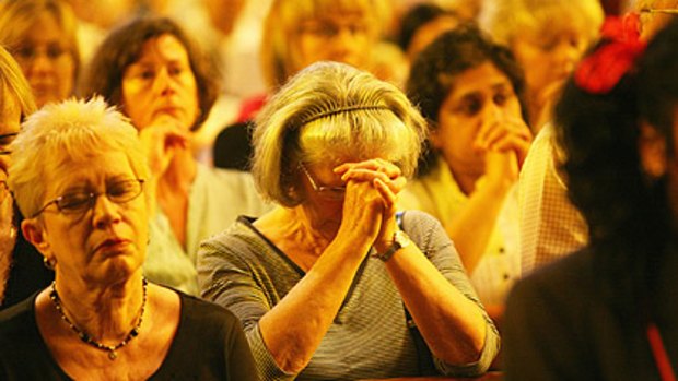 People join in prayer at a bushfire memorial service at St Patricks Cathederal in Melbourne.