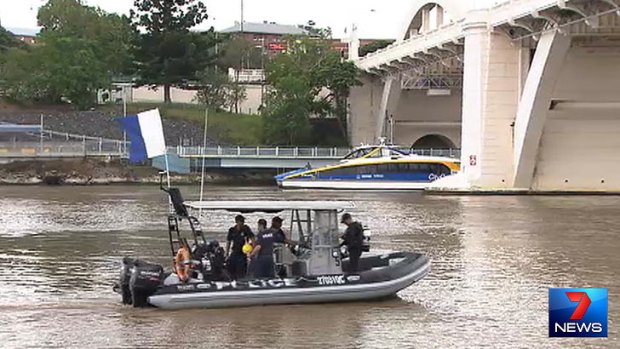 Police divers prepare to search the Brisbane River on Monday.