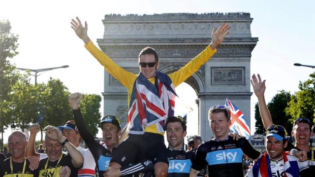 Long road to victory ... Bradley Wiggins is held aloft by his teammates as they celebrate in front of the Arc de Triomphe.