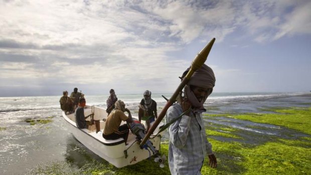 International problem ... a Somali pirate  carries a  rocket-propelled grenade near a  boat with some of his crew.