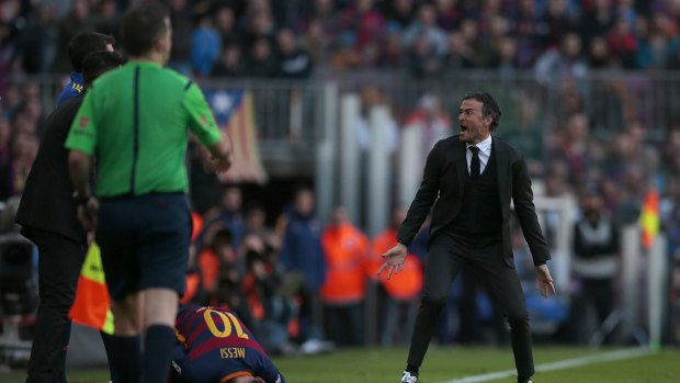 FC Barcelona's coach Luis Enrique, right, reacts after Lionel Messi, is tackled by Filipe Luis.
