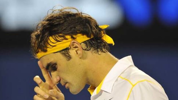 That was close: Roger Federer wipes away sweat during his clash with Gilles Simon last night.