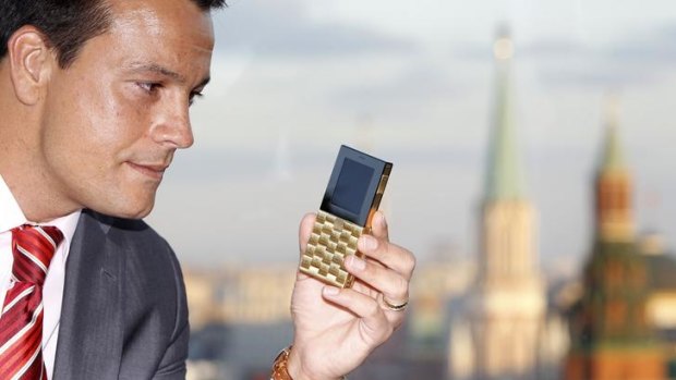 Mathias Rajani, Aesir's chief commercial officer, holds a model of his company's new mobile phone during a press presentation in Moscow.