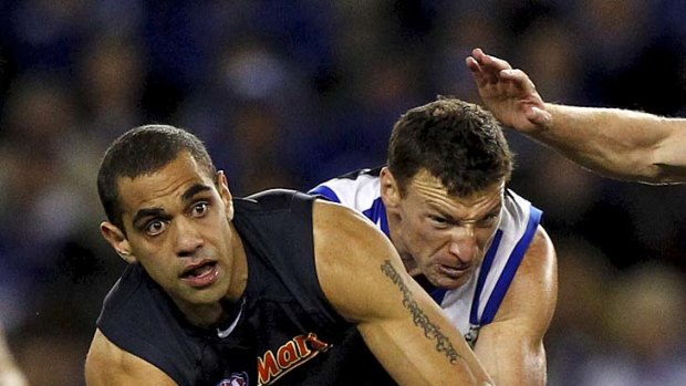 A passing phase: Chris Yarran tries to handball while being tackled by Brent Harvey last night.