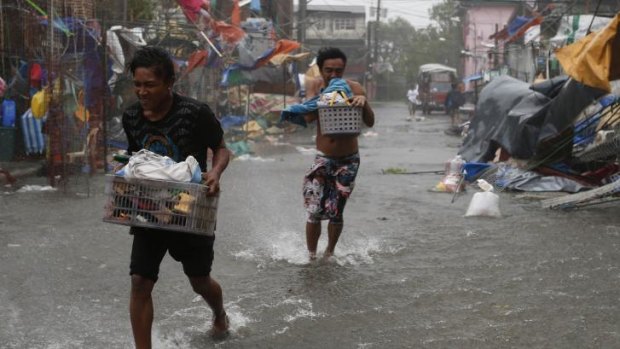 Residents carry their belongings as Typhoon Rammasun hits Imus.