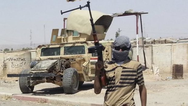 A fighter of the Islamic State of Iraq and the Levant (ISIL) stands guard at a checkpoint near Baiji, north of Baghdad.