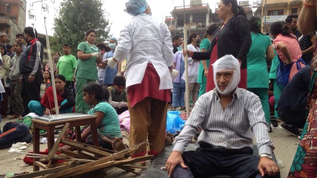 Injured people receive treatment outside the Medicare Hospital in Kathmandu, Nepal.