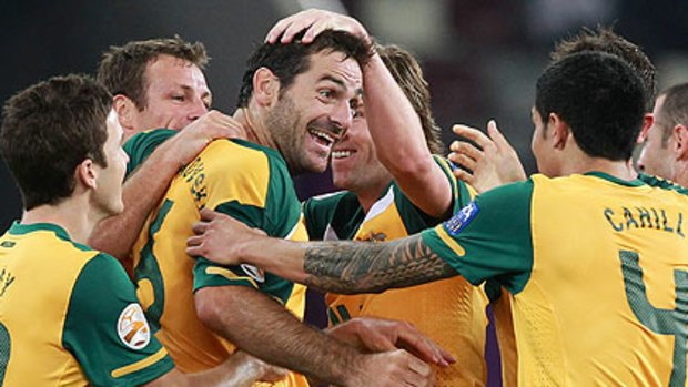 Sasa Ognenovski celebrates with his Soccerooo teammates.