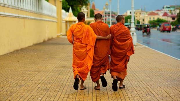 Deeply moving ... monks pass the Royal Palace in Phnom Penh, Cambodia.