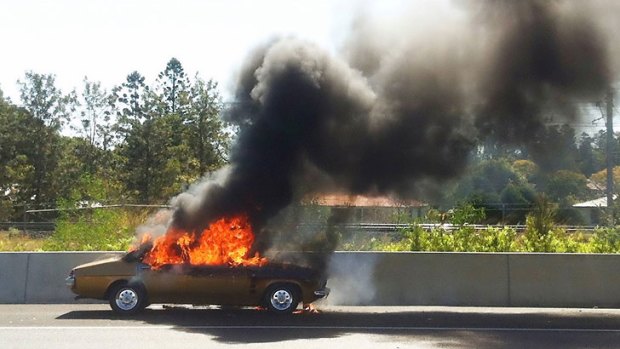 A Holden Kingswood catches fire on the Ipswich Motorway.