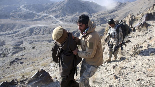 Afghan border policemen escort a  suspected Taliban fighter in Paktika province near the border with Pakistan.