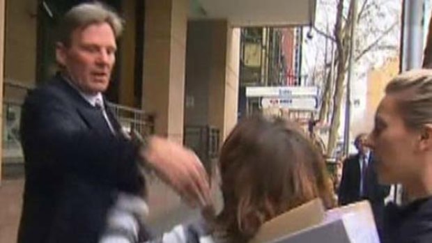 A woman confronts Sam Newman outside the court.