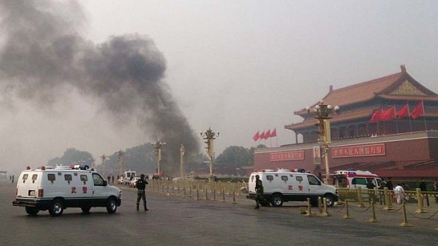 Crash: Police cars block off the roads leading into Tiananmen Square as smoke rises into the air after a four-wheel-drive crashed in front of Tiananmen Gate, running into crowds.