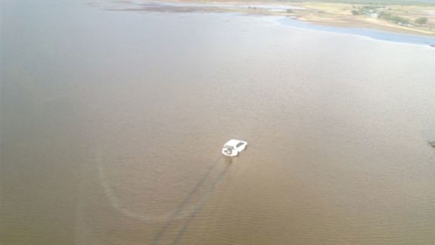 A car travels through floodwaters in Kununurra.