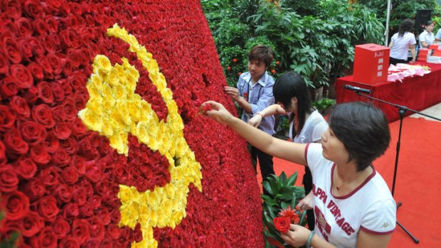 Blossoming street cred ... Chinese volunteers arrange a bed of flowers in a form of the flag of the Chinese Communist Party last year.