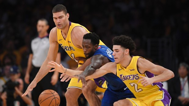 Scramble: Lakers center Brook Lopez and guard Lonzo Ball reach for a loose ball against Clippers guard Patrick Beverley.
