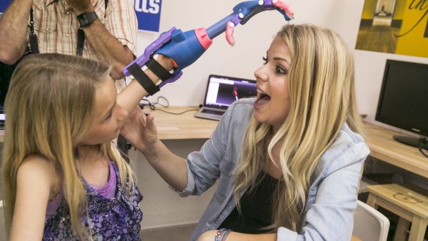 Faith Lennox, 7, left, shows her mother Nicole her newly 3D-printed hand.