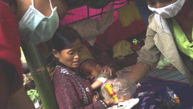 A mother and child receive medical aid in a jungle in the far north of Burma, where soldiers have been fighting rebels since a 17-year ceasefire ended in June.