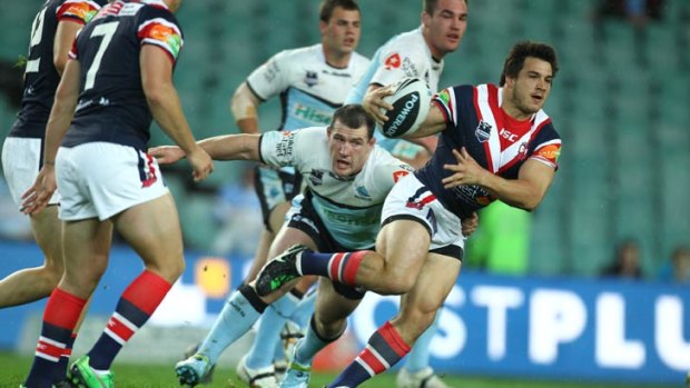 Justin Carney of the Roosters is tackled by Sharks' skipper Paul Gallen.