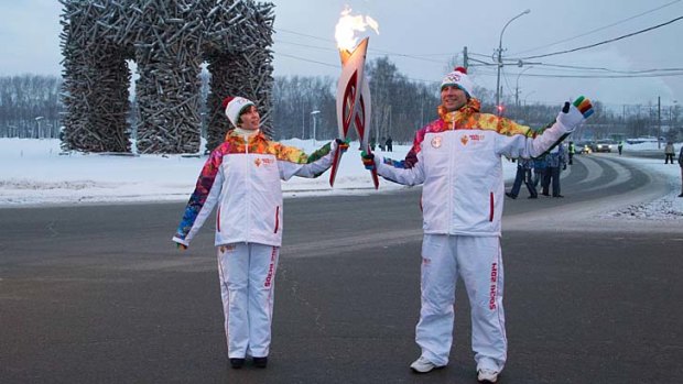 Torch bearers Alexei Popov and Yelena Kulagina hold torches in Perm, Russia, on Saturday during the torch relay for the Sochi Winter Games.