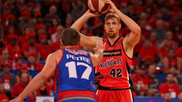 Shawn Redhage of the Wildcats looks to pass over Anthony Petrie of the 36ers.