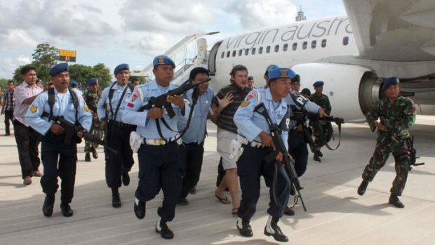 Matt Lockley being arrested by Indonesian Air Force soldiers after landing on the Virgin Australia 737-800 plane at Ngurah Rai airport in Denpasar.