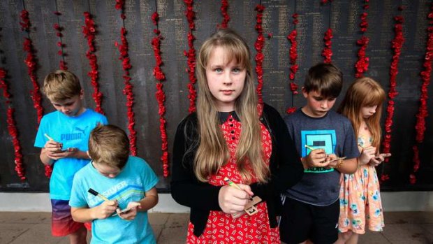 These special Anzac Day messages written on wooden crosses are part of an extensive centenary program by the Memorial aimed at placing almost 100,000 crosses on the overseas war graves of Australians during the next four commemorative years of the First World War. (From left) Blake Bennie age 11, Austin Bennie age 7, Eliza Niven age 12, Matthew Rutter age 11 and Tessa Niven age 10.