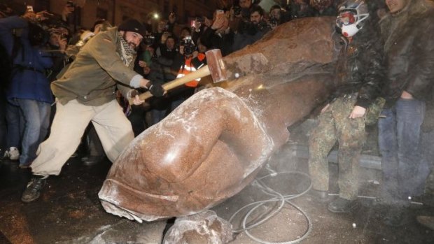 Ukrainians break a monument of Vladimir Lenin in Kiev, Ukraine. The third week of protests continued with an estimated 200,000 Ukrainians occupying central Kiev to denounce President Viktor Yanukovych.