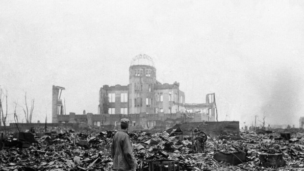 An Allied correspondent stands in the rubble of Hiroshima a month after the first atomic bomb was dropped by the US. 
