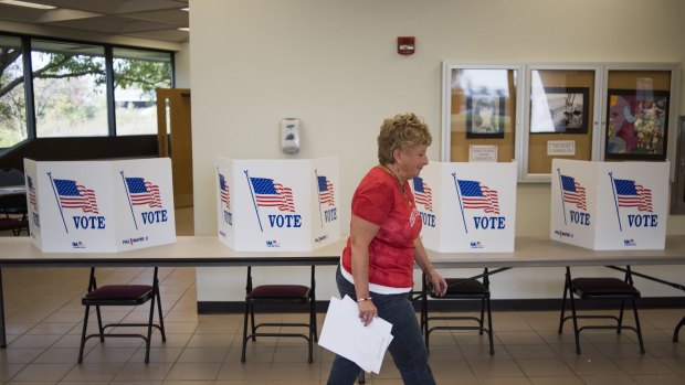 A polling official walks past voting booths in Lancaster, Ohio.