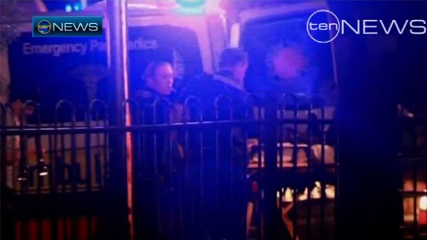 Paramedics treat Senior Constable Leeding after last night's shooting.