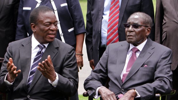 Emmerson Mnangagwa, left, then Vice President of Zimbabwe chats with Zimbabwean President Robert Mugabe after the swearing in ceremony at State House in Harare. 